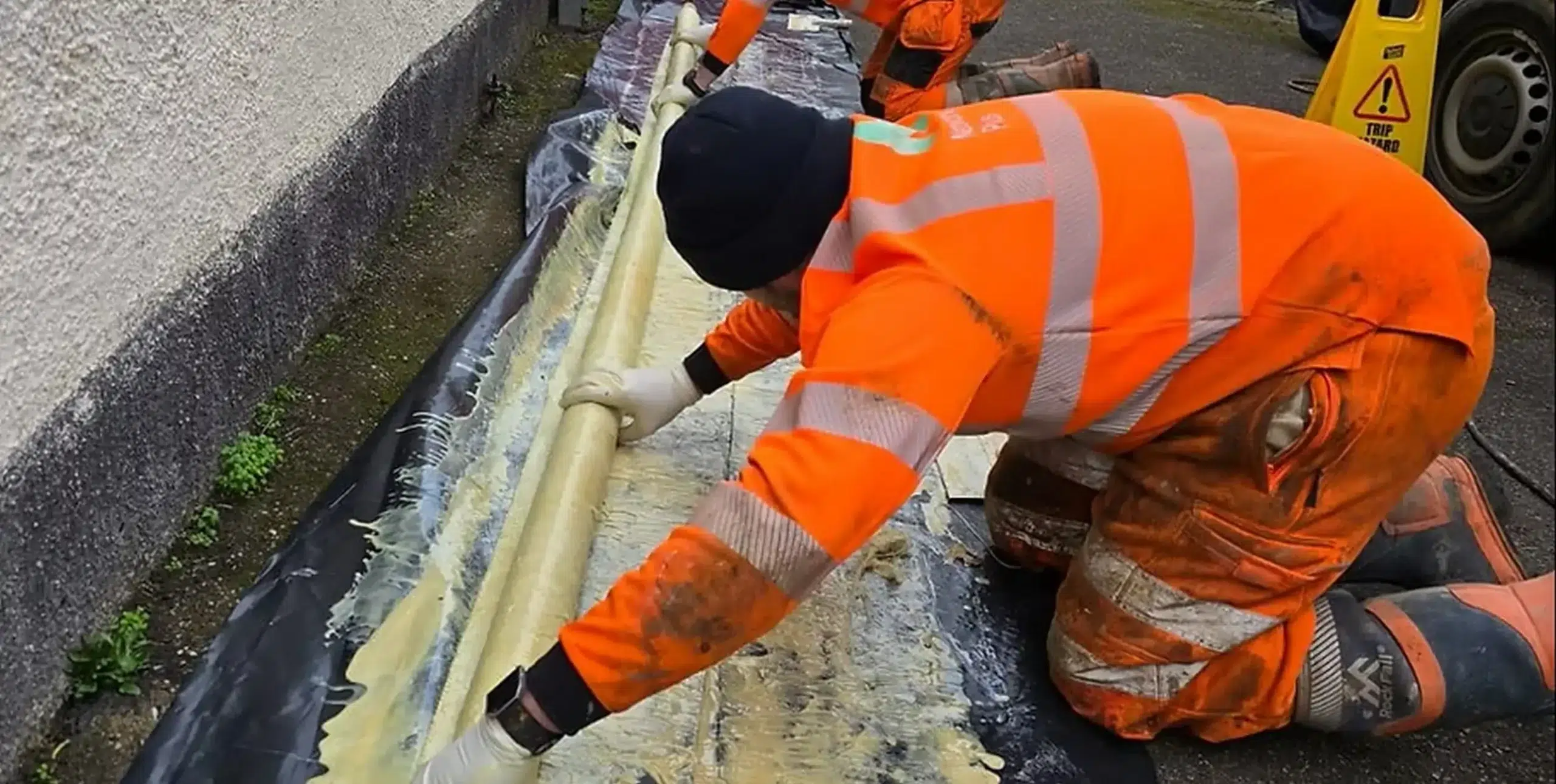 Drainblock Services technicians preparing a resin liner for a pipe patch repair.